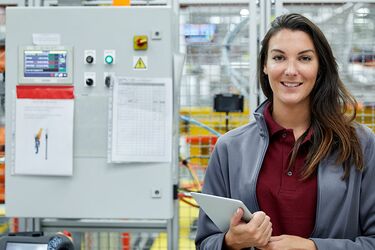 Frau mit Tablet in Industriehalle