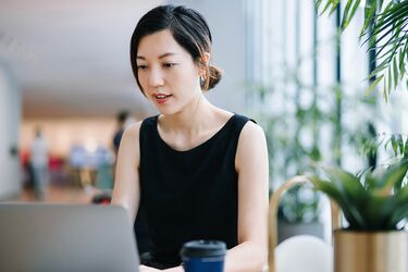 Frau recherchiert am Laptop in Flur