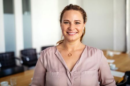 Porträt einer lächelnden Frau in einem hellen Büroraum