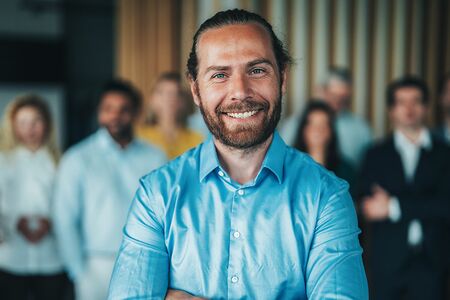 Businessmann Steht vor einer Gruppe Menschen und lächelt