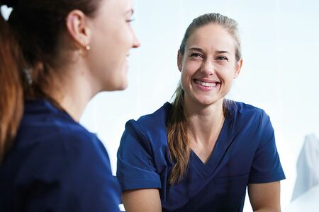 Krankenschwester im Gespräch mit einer Kollegin