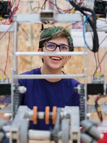 Student arbeitet direkt an Maschinen, da sein Fernstudium Maschinenbau den direkten Praxisbezug hat