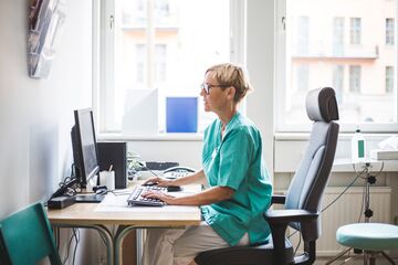 HFH Therapie- und Pflegewissenschaften Bachelor Pflegerin sitz im Büro am Laptop