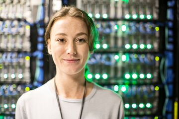 HFH Wirtschaftsinformatik Bachelor Frau steht vor Server und guckt in die Kamera