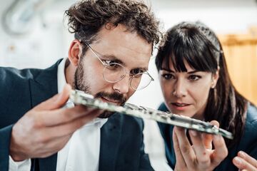 HFH Bachelor Mechatronik Mann und Frau gucken sich eine Platine von nahem an
