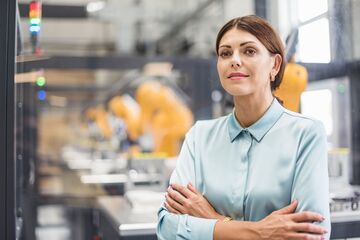 HFH Master Maschinenbau Frau steht in Produktionshalle und guckt nachdenklich