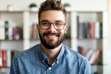 HFH Master Psychologie Mann mit blauem Hemd und Brille lächelt in die Kamera
