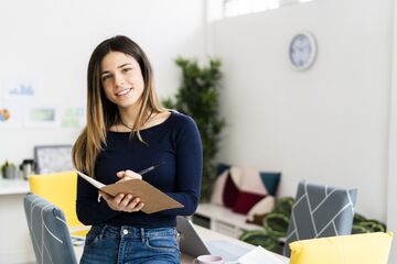 Frau in Büro mit Notizblock