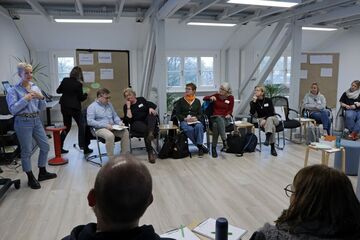 Workshop-Teilnehmer und Dozentin in einem Raum