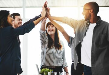 Eine Gruppe Menschen gibt High Five