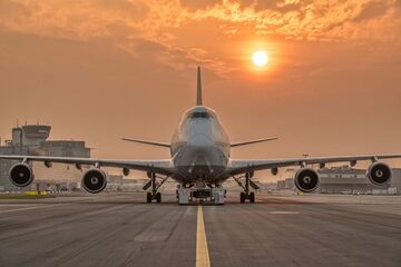 Jumbo-Jet von vorn auf dem Rollfeld mit Sonne im Hintergrund